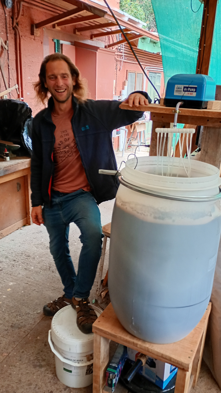 Alexander Maier junto a una preparación de té de compost aireado con bomba de aire y sistema de aireación
